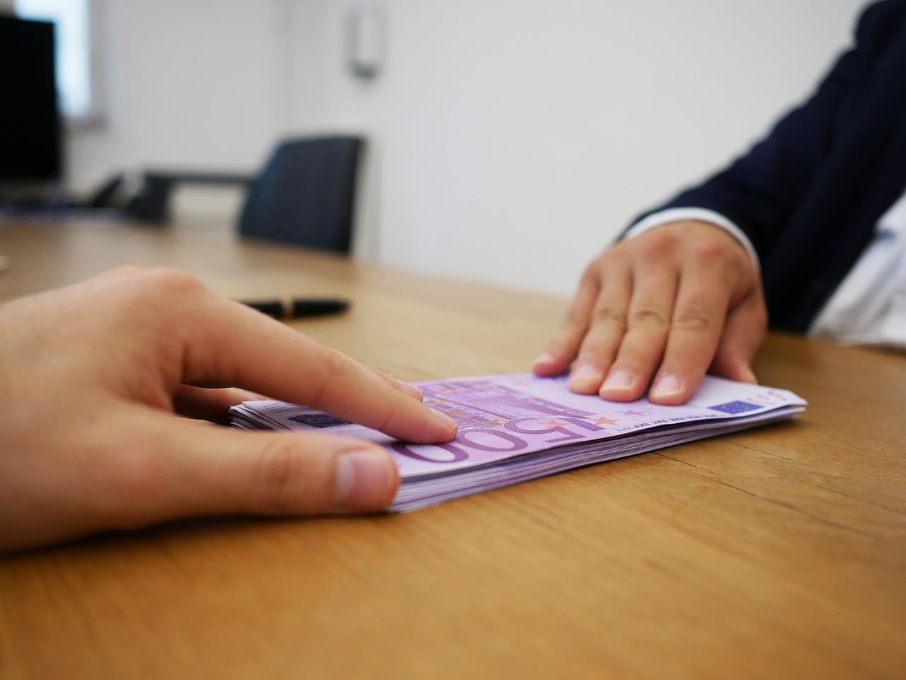 Giocatori di Affari Tuoi sorridono con buste colorate, rappresentando il gioco e le sorprese sugli stipendi.